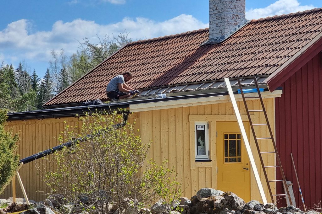 Hantverkare lägger tak på hus i Järna